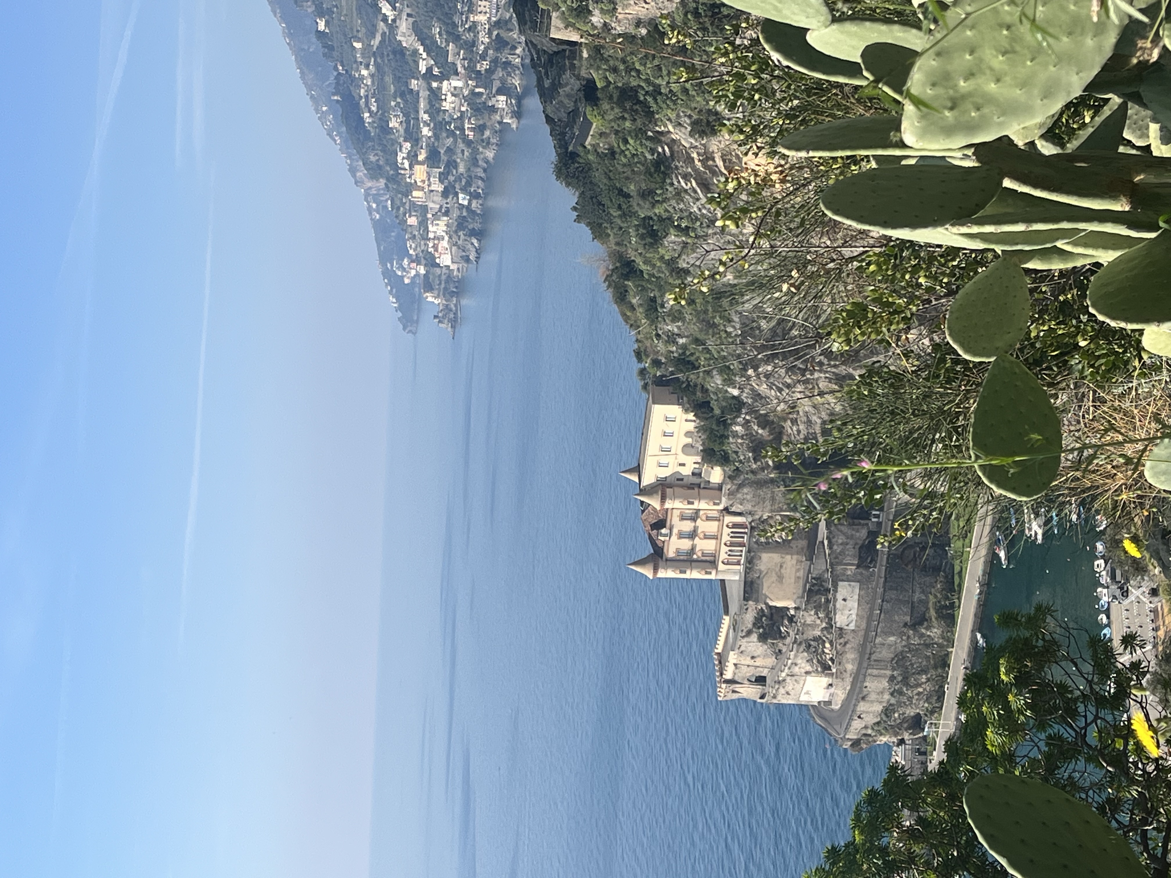 Coastal view with historic building on cliffside.
