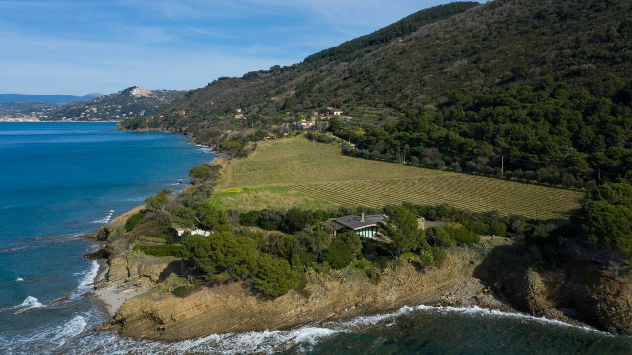 Coastal landscape with a house on a cliff by the sea.