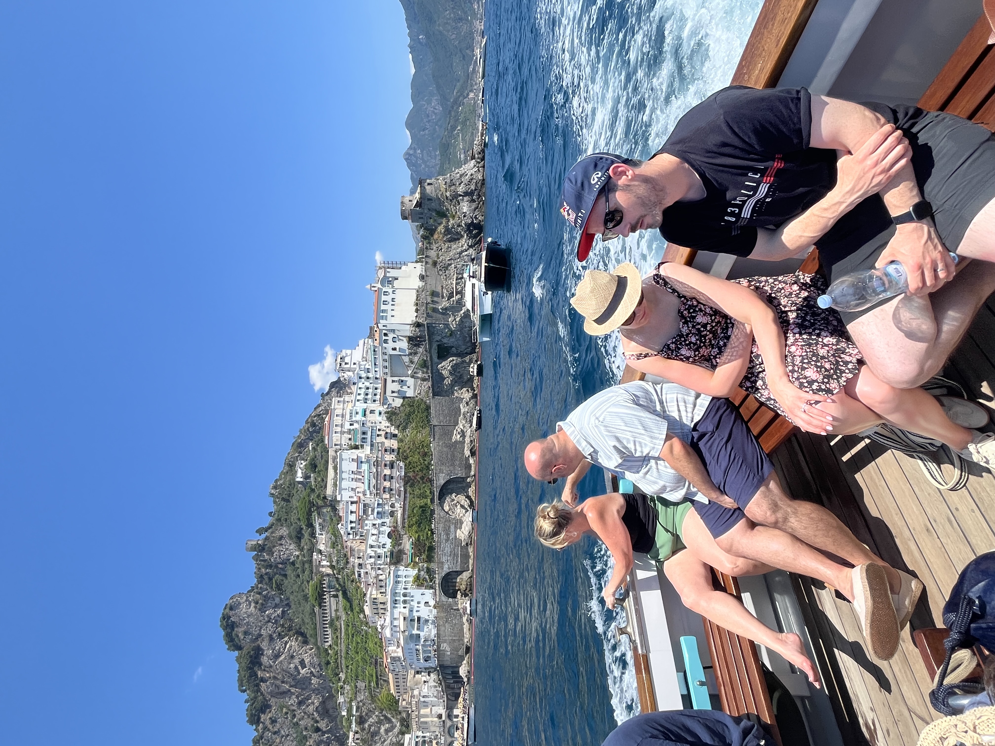 Boat passengers enjoying views of a coastal town and cliffs.