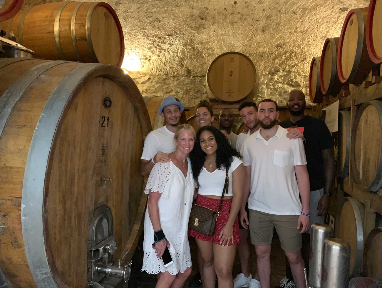 Group inside wine cellar with large barrels.