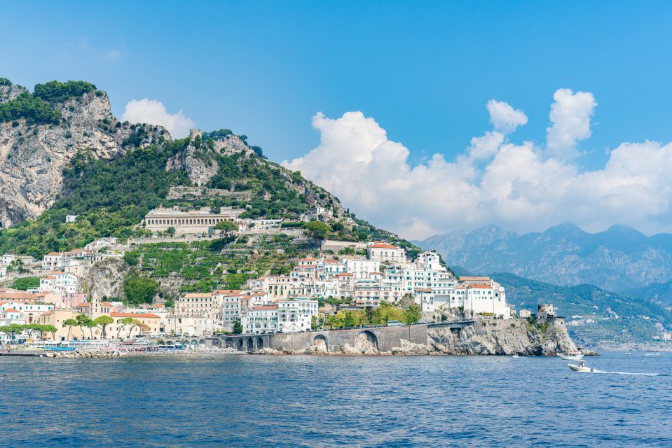 Coastal town with white buildings on a cliff by the sea.