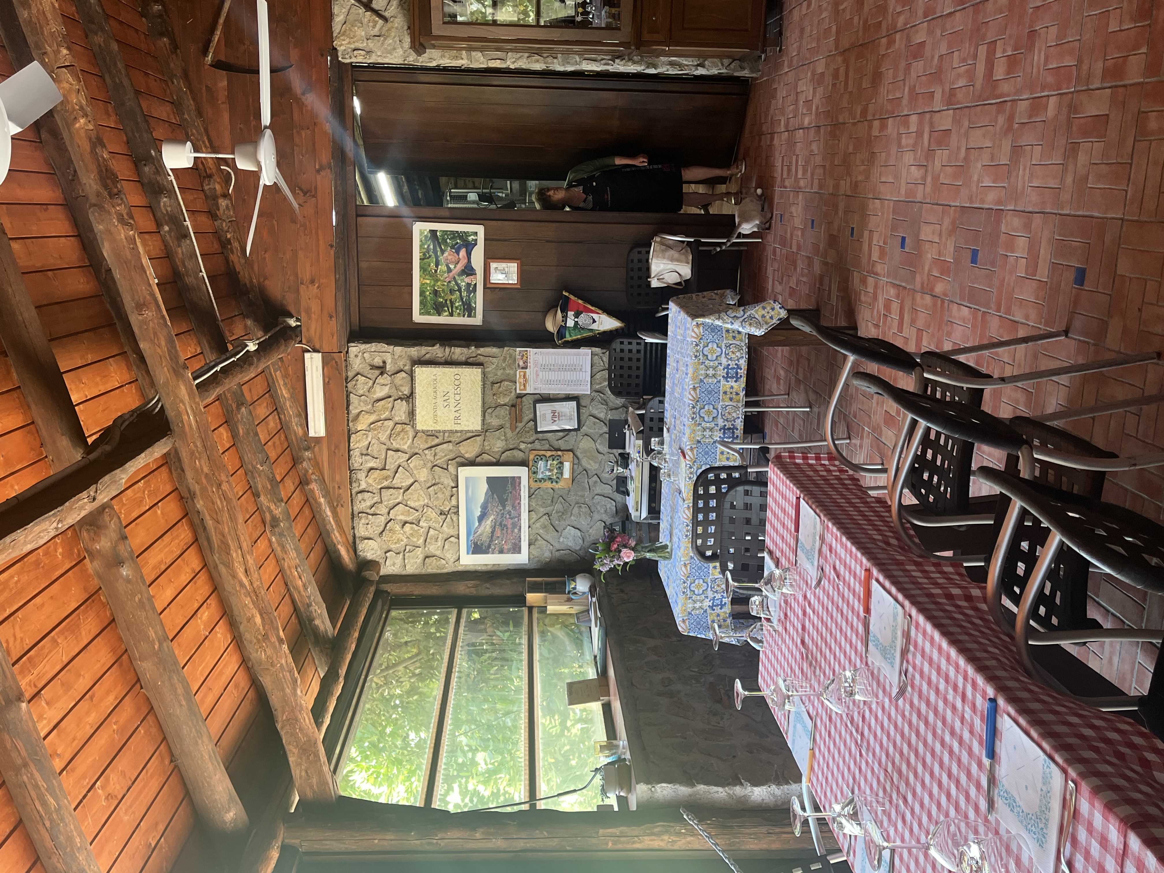 Rustic dining area with wooden beams and stone walls.
